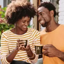 Monsieur et madame boivent du café dans des tasses